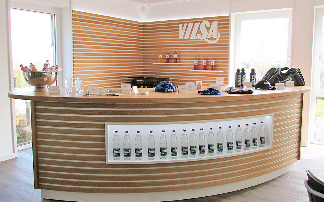 Spezialanfertigung im Innenausbau bei der Vilsa GmbH als Empfangstresen mit integrierten Wasserflaschen.