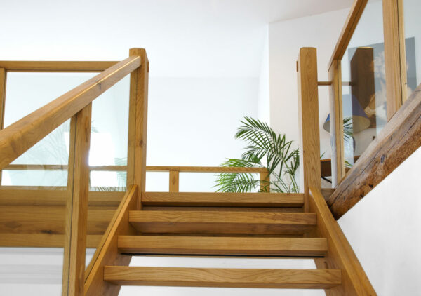 Tischler-Referenzprojekt im Raum Bassum: Diese handwerkliche Treppe von der Tischlerei Albers verbindet die Geschosse auf beeindruckende Weise mit massivem Holz und Glas-Seitenwänden. 
